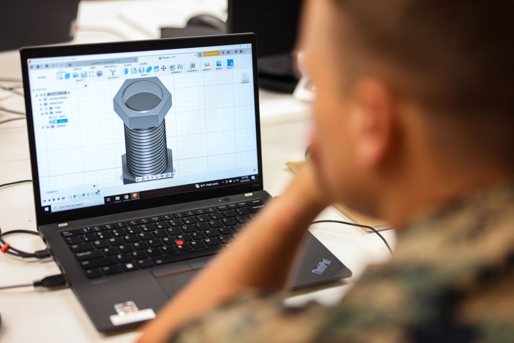 soldier viewing a CAD design on a laptop