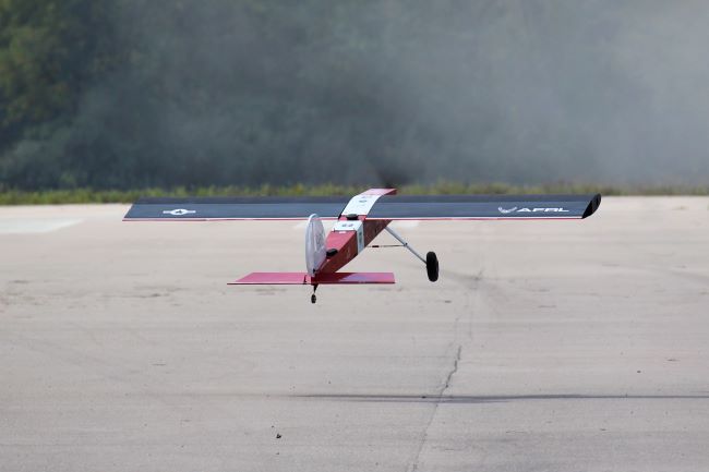 A plane marked with an AFRL logo is taking flight