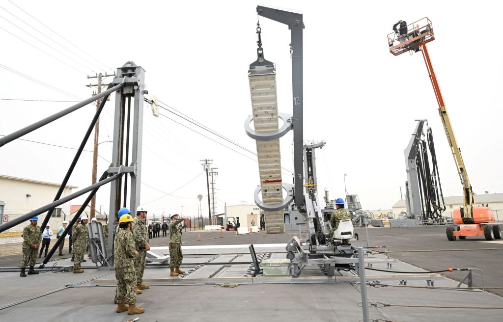 Sailors from the Naval Expeditionary Logistics Support Group and USS Chosin (CG 65) guide a missile canister using the U.S. Navy’s Transferrable Rearming Mechanism as they demonstrate the ability to reload a Vertical Launching System cell on July 11 at Naval Surface Warfare Center, Port Hueneme Division’s Underway Replenishment Test Facility. (U.S. Navy photo/released)