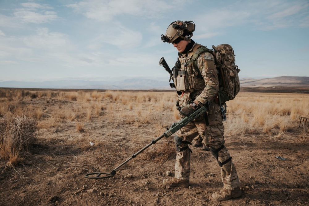 Service member operating a mine detection tool.