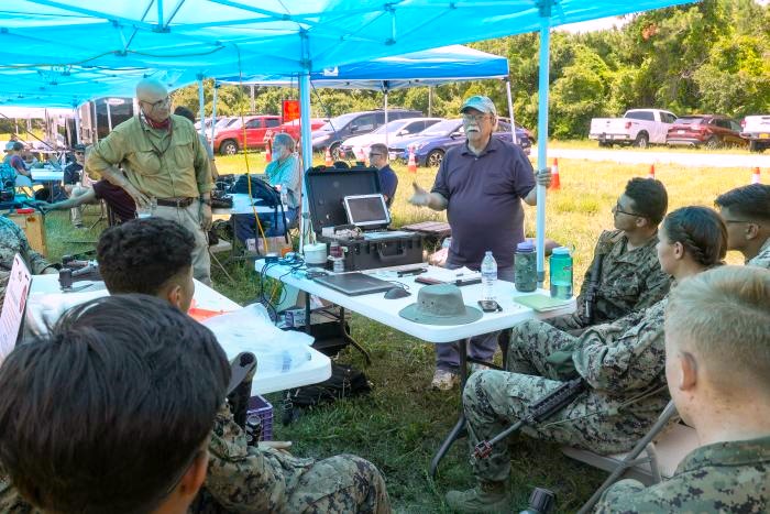 Peter DeSalva (standing, left), an ONR subject matter expert and support contractor, and Dr. John Tucker (standing, right), a Naval Research Laboratory physicist, teach Marines about the Portable Fluid Analyzer Plus system during the Technology Operational Experimentation Exercise 2022 at Camp Lejeune, North Carolina. (U.S. Marine Corps photo by Lance Cpl. Jessica J. Mazzamuto)