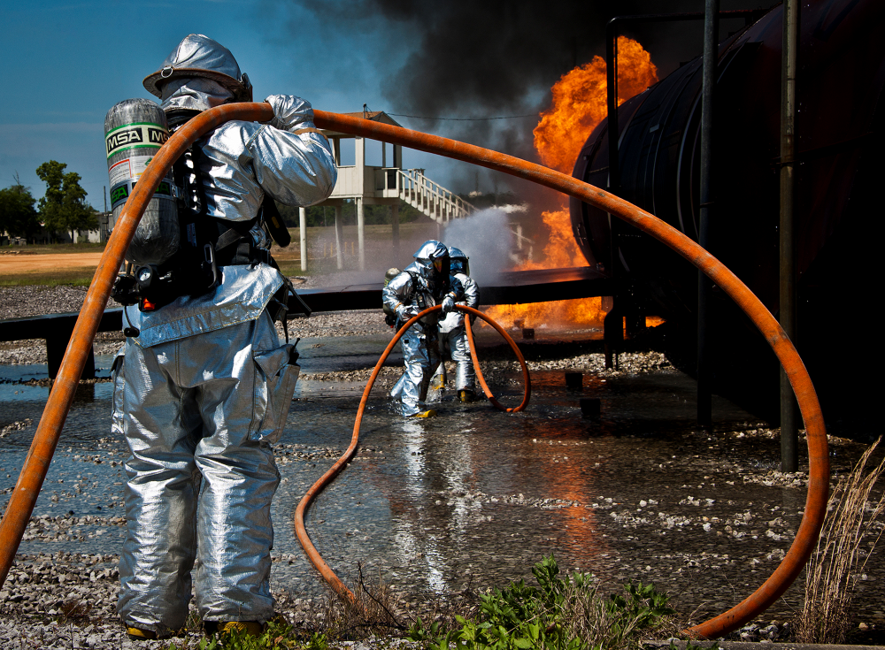 Military First Responders holding a fire hose for fire control operations.