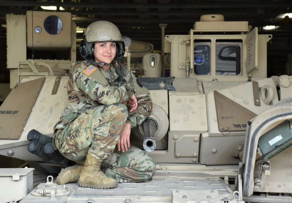 Image of a military servicemember sitting atop a military fighting vehicle.