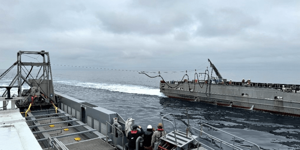 In a test as part of DARPA’s NOMARS program, the USV Mariner (right) deploys a refueling probe towards the USV Ranger (left) in the first test of fueling at sea (FAS) without any human interaction required on the part of the receiving vessel. The personnel aboard the Ranger are observers only. Credit: DARPA