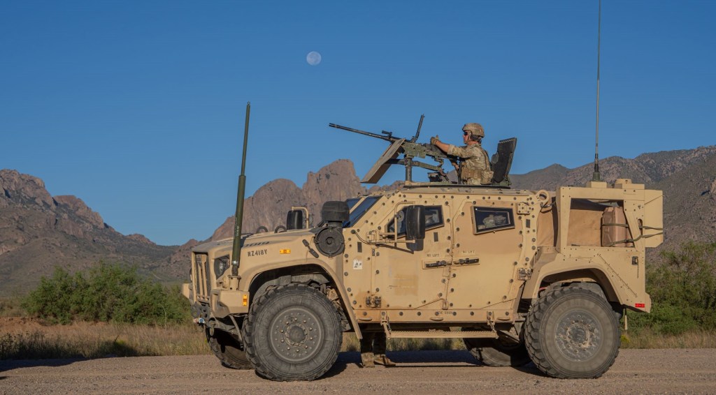 U.S. Army indirect-fire infantryman, Spc. Andrew Wilson assigned to Headquarters and Headquarters Company, 2nd Battalion, 37th Armor Regiment, 1st Armored Brigade Combat, 1st Armored Division, stands by to receive ammo while in a Joint Light Tactical Vehicle (JLTV) with a mounted M2A1 .50 cal heavy machine gun in preparation to conduct Mounted Machine Gun Gunnery Table V at McGregor Range, New Mexico, Sep 19, 2024. (U.S. Army photo by Cpl. David Poleski)