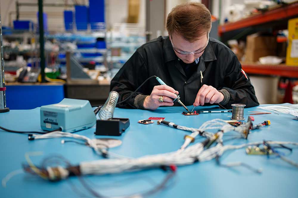 RAPID PROTOTYPING — An electrical engineer works on soldering for Core SkyFox. The project includes the use of commercial off-the-shelf parts and systems for rapid prototyping and testing of hypersonic flight testing. (Photo by Craig Fritz)