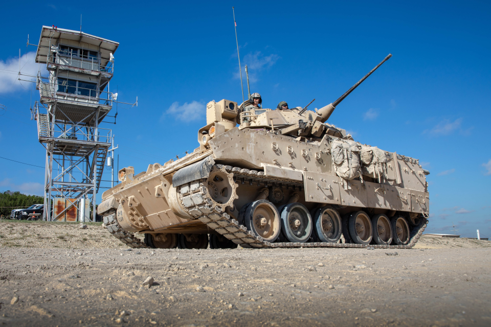 Image of a tracked vehicle with personnel operating it.
