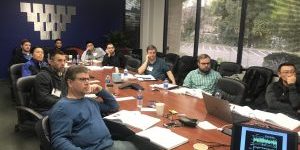 people sitting at a long, rectangular table for a meeting