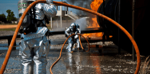 Military First Responders holding a fire hose for fire control operations.