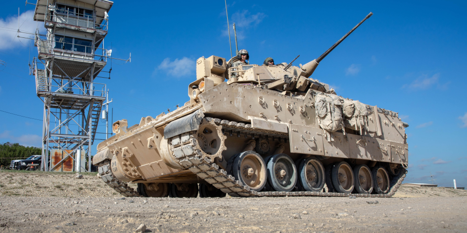Image of a tracked vehicle with personnel operating it.