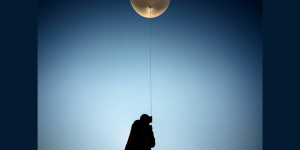 Summer Czarnowski, a geosciences intern at Sandia, holds a line tethered between a scientific payload and a weather balloon prior to launch at Moriarty Airport in New Mexico in July. (Photo by Craig Fritz)